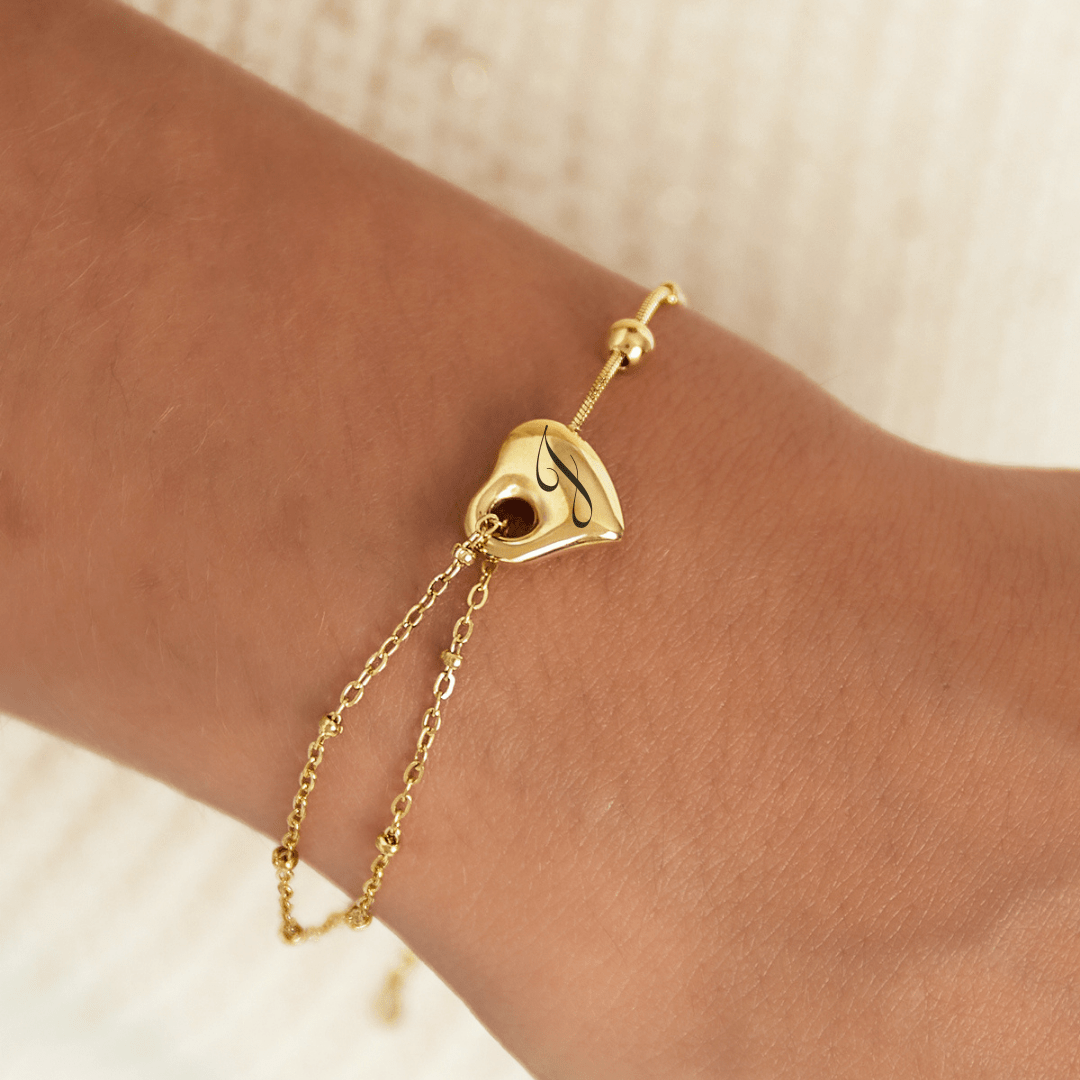 Bracelet en acier inoxydable en forme de cœur, personnalisable avec la gravure d’une initiale. Taille ajustable 15 cm + 3 cm.