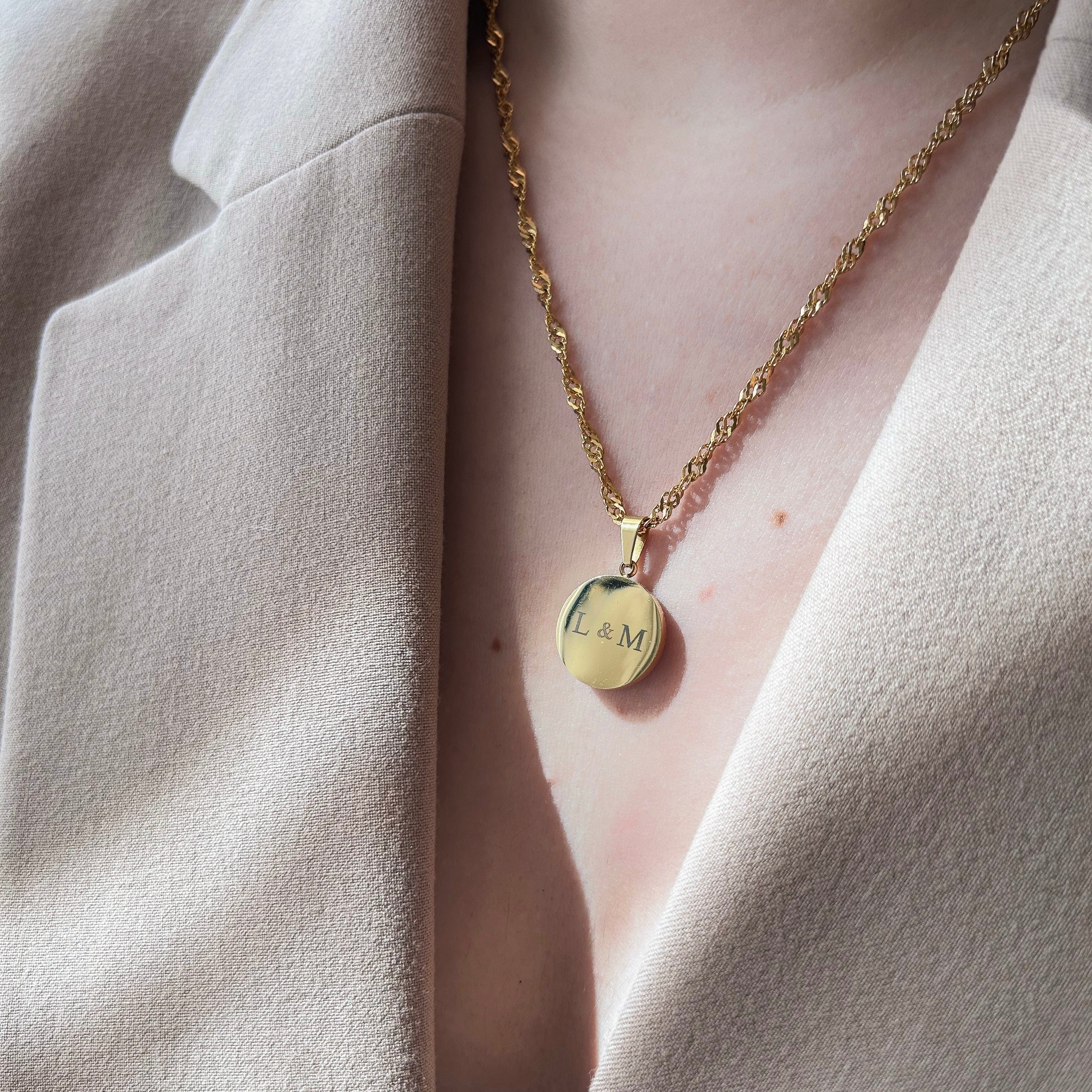 Collier rond en acier inoxydable et résine, diamètre 1,5 cm, personnalisable avec cheveux, poils d’animaux ou cendres. Possibilité d’ajouter initiales, feuille d’or, gravure de texte, symbole ou photo au dos