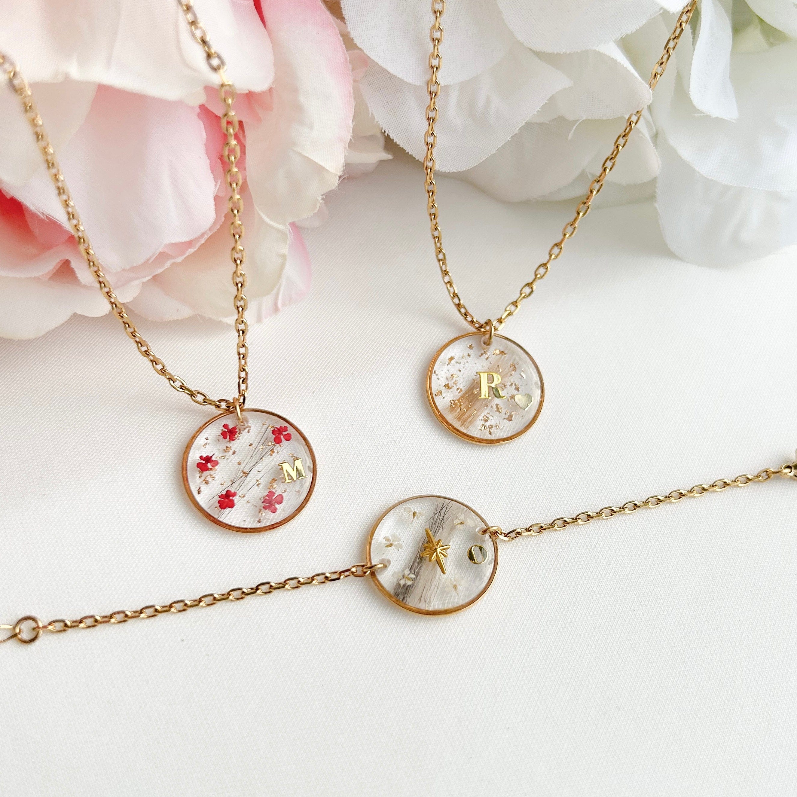 Collier rond en acier inoxydable et résine, diamètre 2 cm, personnalisable avec cheveux, poils d’animaux ou cendres. Possibilité d’ajouter initiales, feuille d’or et symboles au choix.